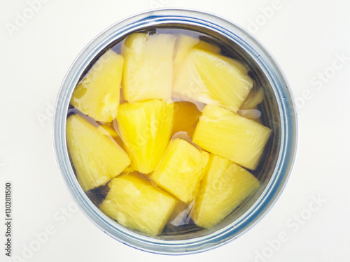 A closeup, overhead, centred and isolated shot of an open tin can of chopped pineapple chunks in juice.