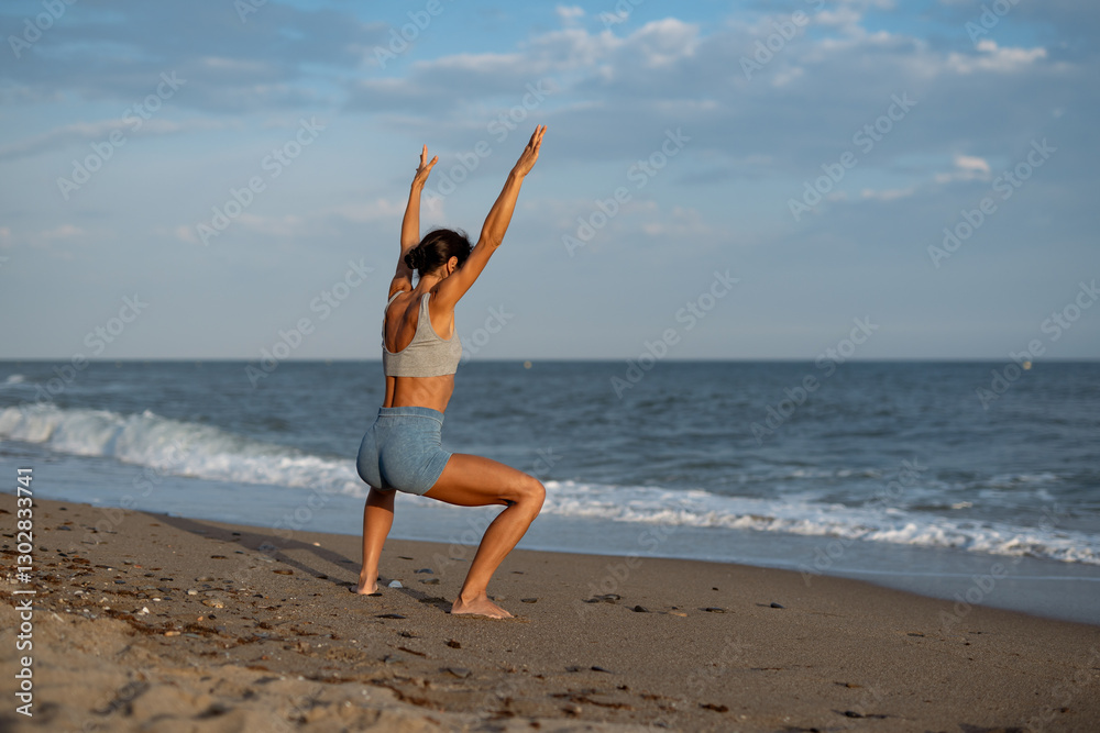 A woman performing a yoga pose on a beach, stretching her arms toward the sky while standing in a low squat position, with the calming ocean waves behind her A woman performing a yoga pose on a beach, stretching her arms toward the sky while standing in a low squat position, with the calming ocean waves behind her