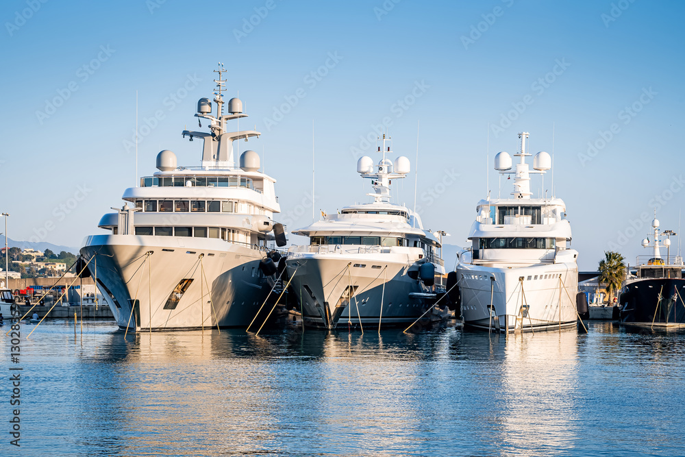 Large surperyacht at dock side by side in a marina, located in Genova, Italy after yard maintenance Large surperyacht at dock side by side in a marina, located in Genova, Italy after yard maintenance