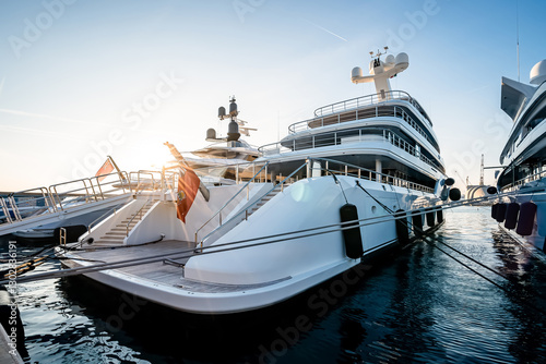 Sunset detail of the stern of a superyachts and megayacht at dock located in Genova, Italy after shipyard maintenance 