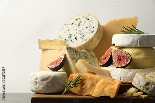 Different types of cheese, rosemary and figs on table, closeup