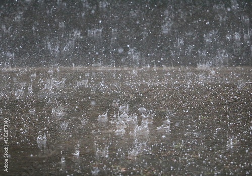 heavy rain falls on the street and splashes in the puddles