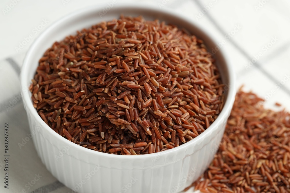 Raw brown rice in bowl on table, closeup Raw brown rice in bowl on table, closeup