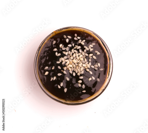bowl of teriyaki sauce and sesame seeds on a white background