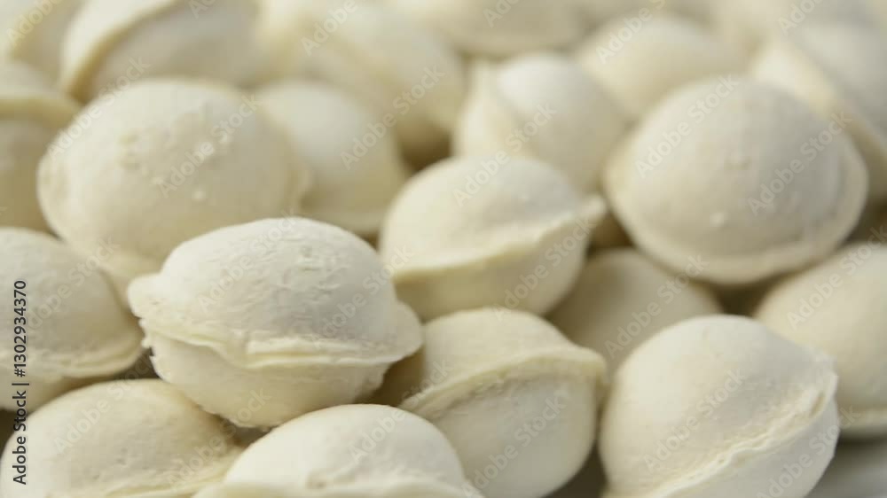 Raw frozen dumplings are rotating. Side view. Frozen food. Homemade preparations. Raw frozen dumplings are rotating. Side view. Frozen food. Homemade preparations.