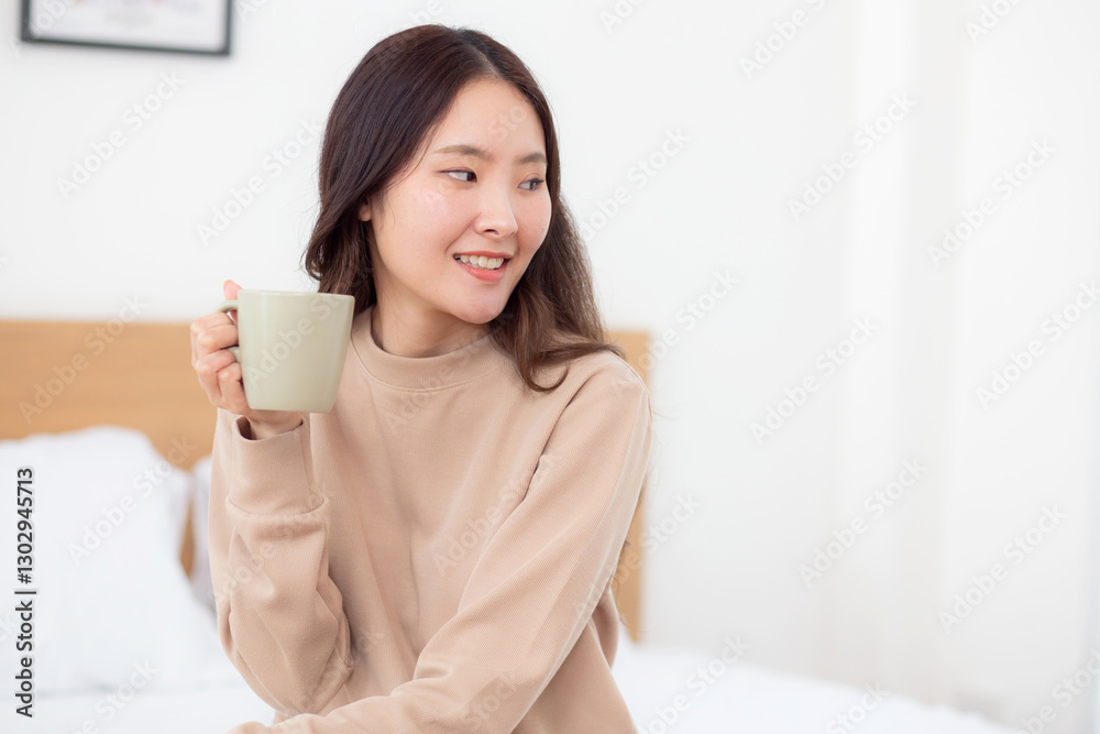 Young asian woman holding and drinking coffee in morning in bedroom at home for relaxation, woman drinking beverage with pleasure and freshness for health, relax and cozy, lifestyle concept. Young asian woman holding and drinking coffee in morning in bedroom at home for relaxation, woman drinking beverage with pleasure and freshness for health, relax and cozy, lifestyle concept.