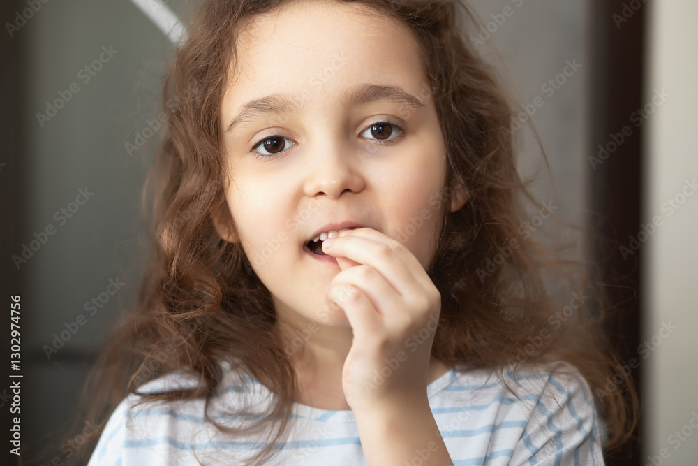 Cute little curly girl loosens a baby tooth with his fingers. First teeth changing. Cute little curly girl loosens a baby tooth with his fingers. First teeth changing.