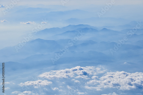 Wallpaper Mural The view of the stunning landscape with mountains and clouds from the airplane window. Aerial view of the natural scene, mountain range. Travel and landscape scene. Travel and nature concept.  Torontodigital.ca
