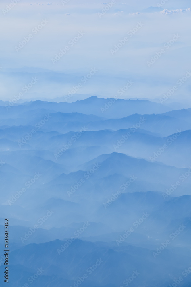 The view of the stunning landscape with mountains and clouds from the airplane window. Aerial view of the natural scene, mountain range. Travel and landscape scene. Travel and nature concept. The view of the stunning landscape with mountains and clouds from the airplane window. Aerial view of the natural scene, mountain range. Travel and landscape scene. Travel and nature concept.