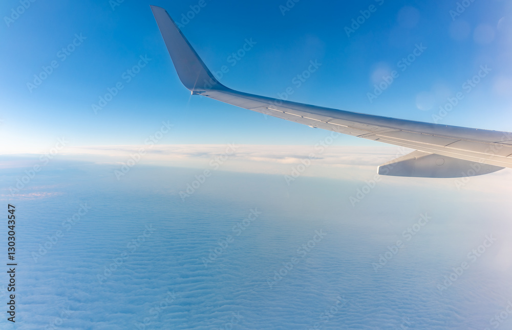 Obraz premium View from the airplane window at a beautiful cloudy sky and the airplane wing