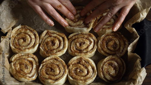 Placing cinnamon rolls in the baking pan. photo