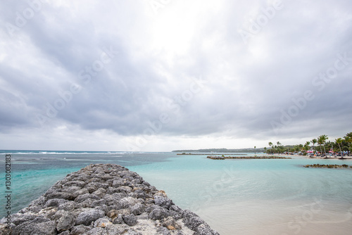 Fototapeta Naklejka Na Ścianę i Meble -  Romantic Caribbean sandy beach with palm trees, turquoise sea. Morning landscape shot at sunrise at Plage de Bois Jolan, Guadeloupe, French Antilles
