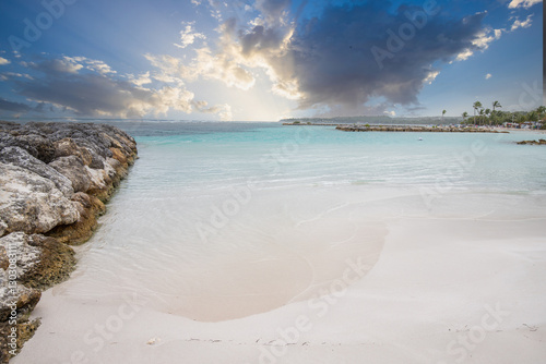 Fototapeta Naklejka Na Ścianę i Meble -  Romantic Caribbean sandy beach with palm trees, turquoise sea. Morning landscape shot at sunrise at Plage de Bois Jolan, Guadeloupe, French Antilles
