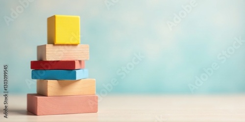 A Stack of Colorful Wooden Blocks Arranged in a Pyramid Shape Against a Light Blue Background