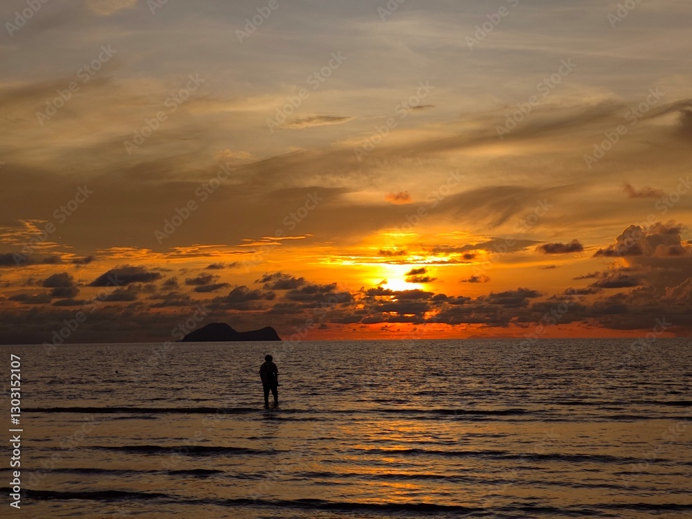 silhouette of a man walking on the beach at sunset silhouette of a man walking on the beach at sunset