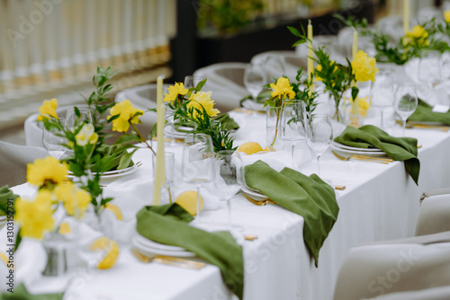 Elegant Table Setting with Yellow Flowers and Green Napkins for a Celebration