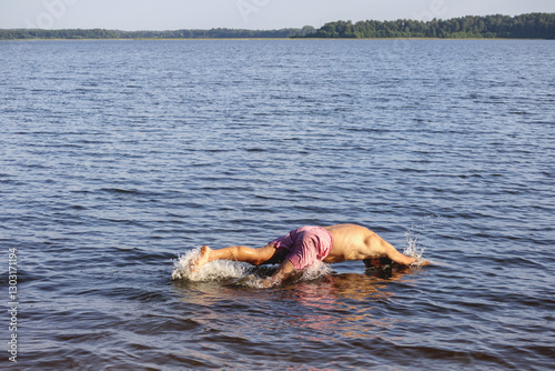 
a man diving headfirst into a lake.