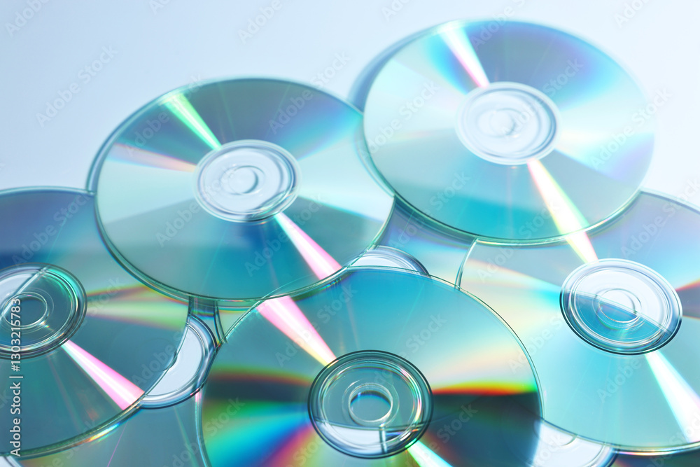 Many shiny compact discs on dusty blue background, closeup Many shiny compact discs on dusty blue background, closeup