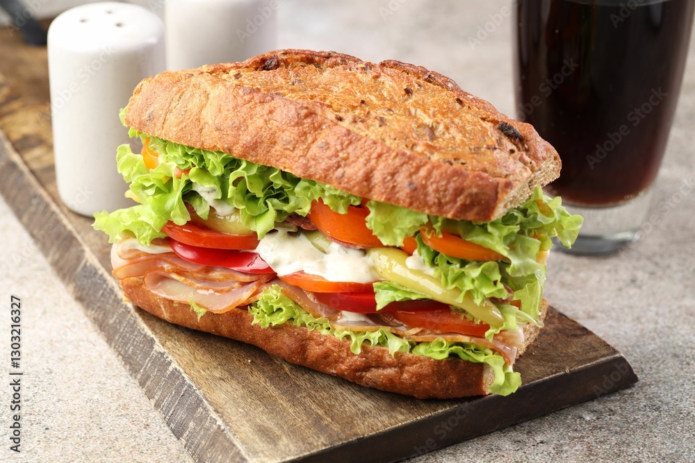 Delicious baguette sandwich with tomatoes and yellow beans on grey textured table, closeup Delicious baguette sandwich with tomatoes and yellow beans on grey textured table, closeup