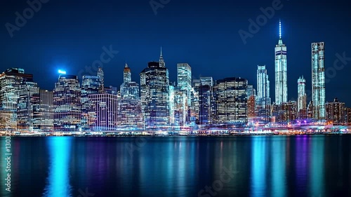 Wallpaper Mural Manhattan Skyline at Night: A captivating panoramic view of the iconic Manhattan skyline ablaze with dazzling lights, reflected in the tranquil waters of the Hudson River. Torontodigital.ca