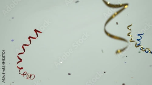 Party background, ribbons and confetti falling in slow-motion