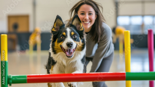 A cheerful woman enjoys quality time training her enthusiastic dog in a bright indoor space filled with agility equipment, showcasing their bond