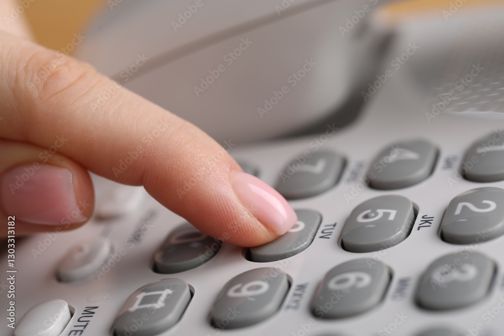 Woman dialing number on landline telephone, closeup Woman dialing number on landline telephone, closeup