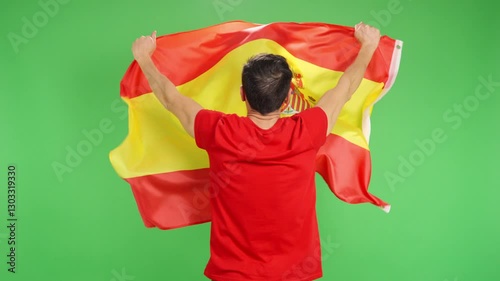 Sports fan holding spanish flag with his back turned