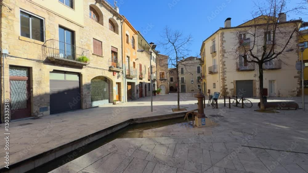 Deserted square with bare tree and water feature in a spanish town Deserted square with bare tree and water feature in a spanish town