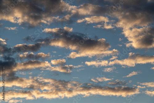 Obraz na płótnie Golden Hour Clouds Illuminated Against a Clear Blue Sky w salonie