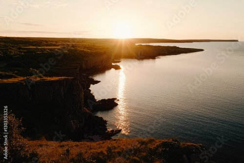 Scenic Coastline Sunset Cliffside view with setting sun and calm ocean waters