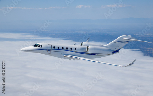 Side view of a Citation X (business jet) over  cloud layers, in beautiful light photo