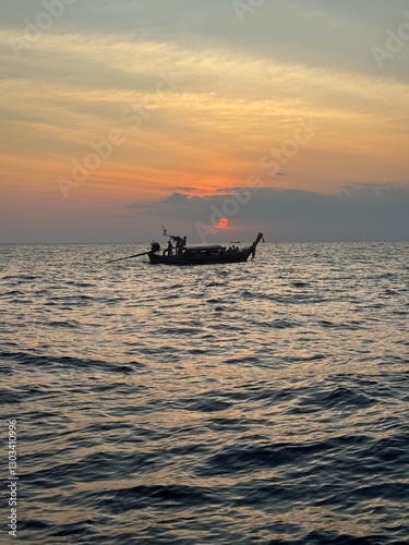 Sun setting over a fishing boat in the ocean