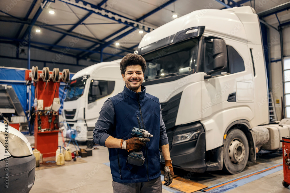 Portrait of diverse mechanic with drill in hands standing at mechanic workshop and preparing for lorry fixing. Portrait of diverse mechanic with drill in hands standing at mechanic workshop and preparing for lorry fixing.