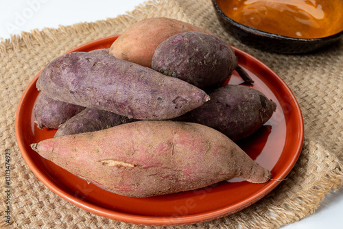Colorful sweet-tasting tuberous roots vegetables purple and orange organic sweet potatos close up
