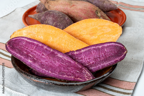Colorful sweet-tasting tuberous roots vegetables purple and orange organic sweet potatos close up
