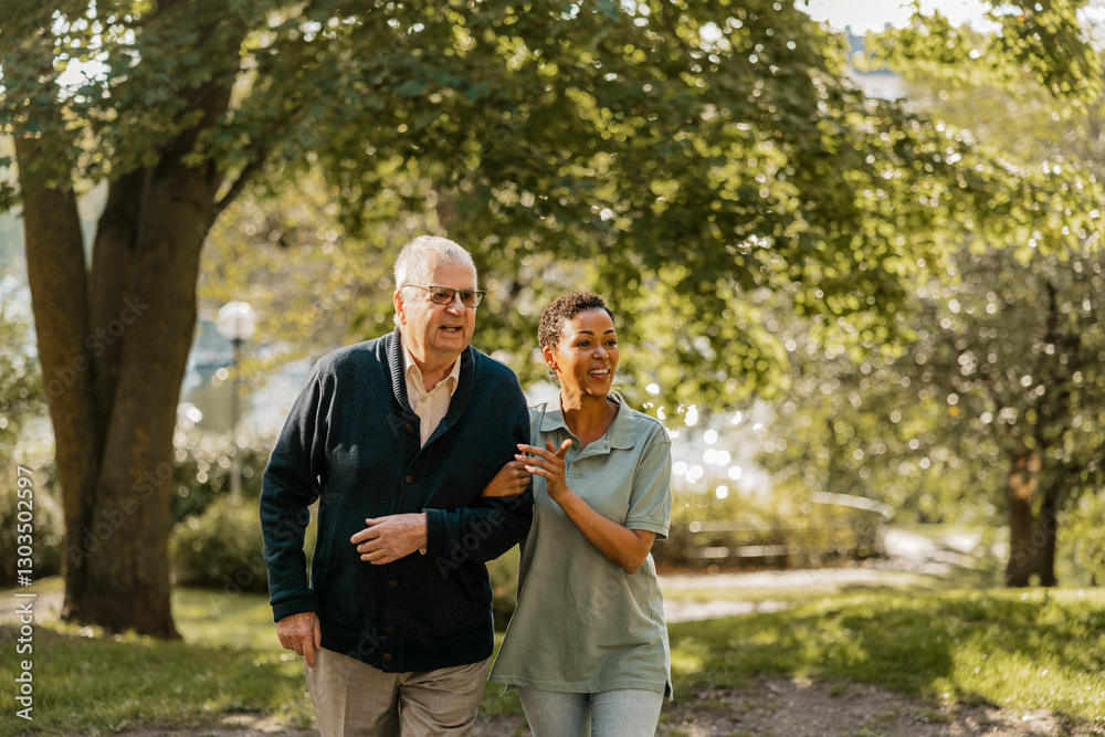 Smiling female nurse spending leisure time walking with elderly male at park Smiling female nurse spending leisure time walking with elderly male at park