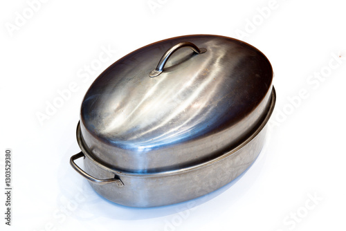A well used stainless steel covered roasting pan isolated on white