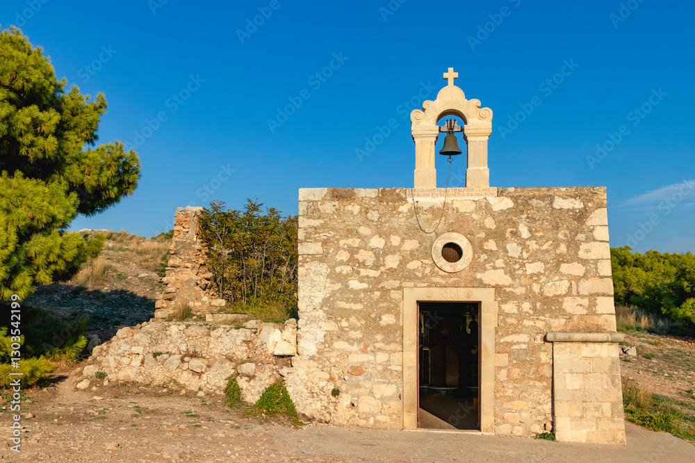 A picturesque stone orthodox chapel with a bell, set amidst beautiful natural scenery. Greece. Rethymno.