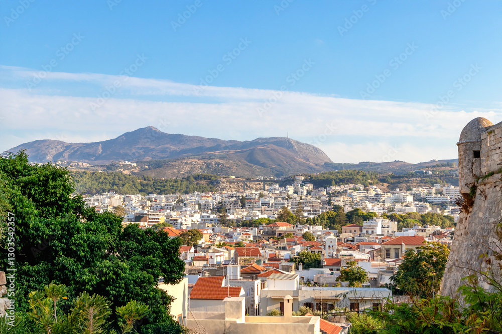 A scenic urban landscape with an enchanting city view and majestic mountains behind. Greece. Rethymno.