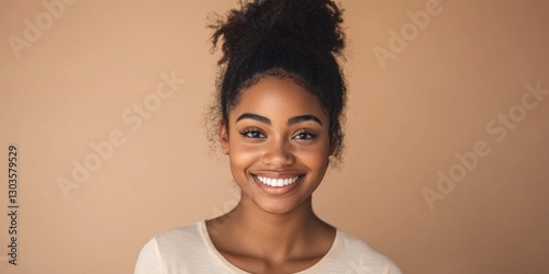Smiling young woman with updo looking at camera.