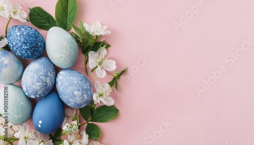 Stylish easter eggs and spring flowers border on pink paper flat lay, space for text. Modern natural dyed blue and marble easter eggs. Happy Easter. Greeting card, invitation, header template