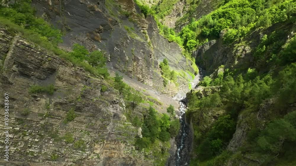 Drone covering a wide aerial view of a mountain river in Eastern Caucasus, Russia, flying along the ridges and capturing the stunning green scenery of Dagestan. Drone covering a wide aerial view of a mountain river in Eastern Caucasus, Russia, flying along the ridges and capturing the stunning green scenery of Dagestan.
