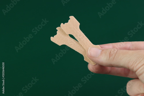 Woman holding a nasal strip in the hands. Close up looking of a nasal strips in a the fingers