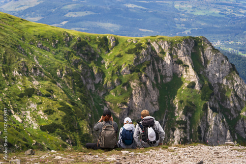 Fototapeta Naklejka Na Ścianę i Meble -  Family of mountain travelers at a halt on a summer day, photo view from the back. Polish mountains in Zakopane.