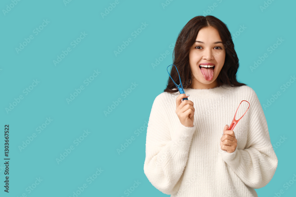 Young Asian woman with tongue scrapers on blue background Young Asian woman with tongue scrapers on blue background