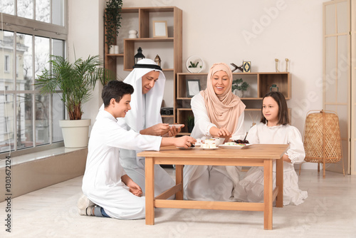 Happy Muslim family sitting...