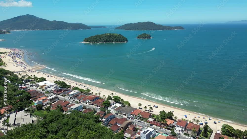 Linda vista aerea com drone sobre o mar com montanhas e cidade ao fundo com cores vibrantes.