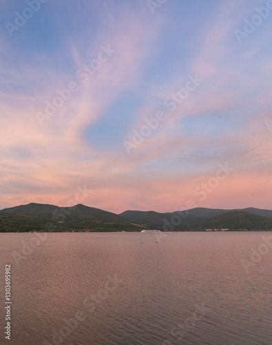 Beautiful sunset over a calm lake with mountains in the background