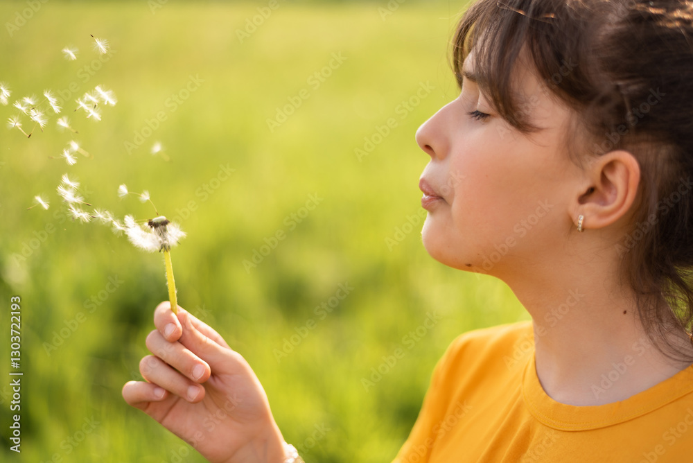 A happy girl blowing dandelion in the spring park. A happy girl blowing dandelion in the spring park.
